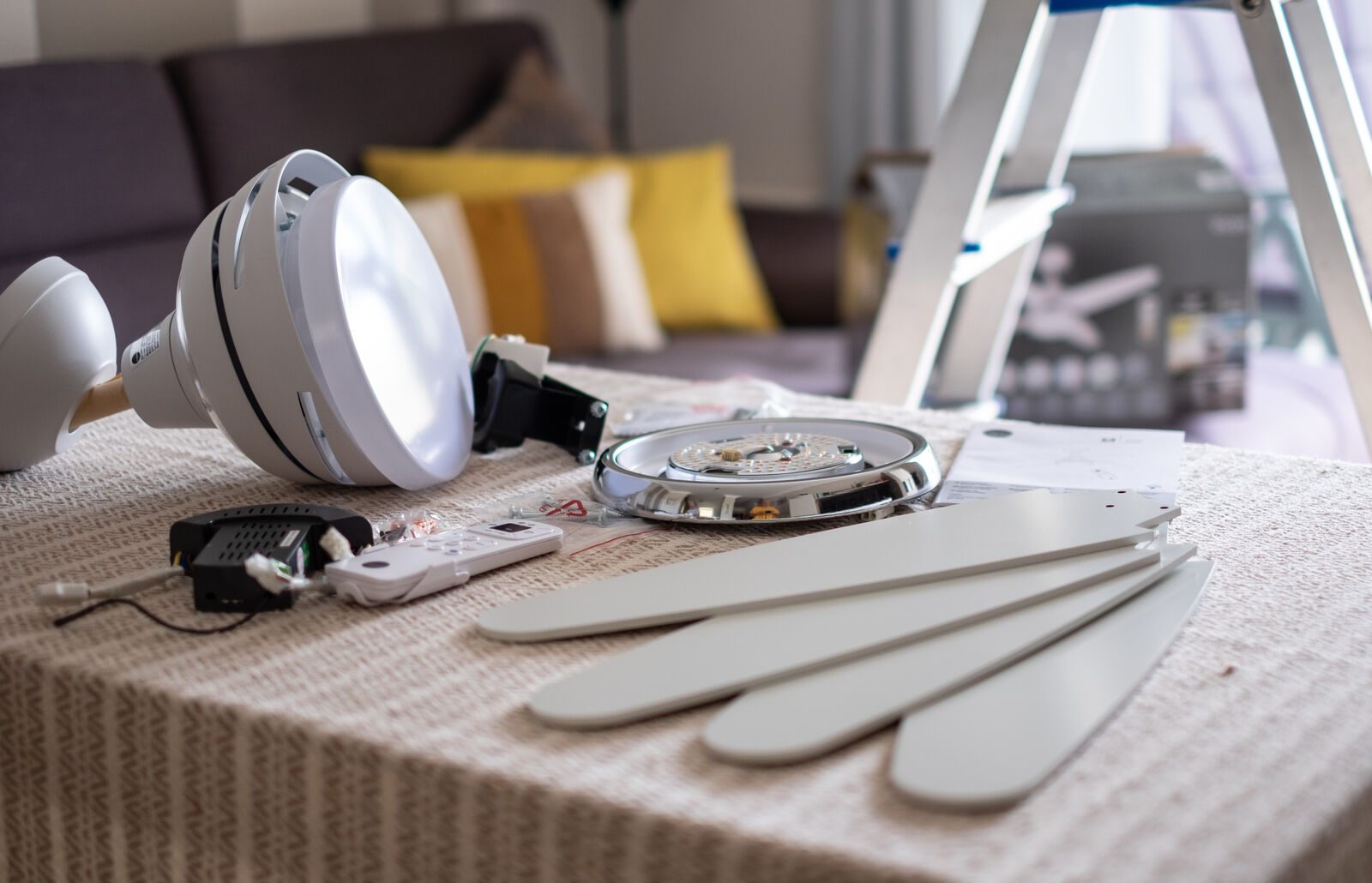 Electrician fitting a ceiling fan and light in a Gauteng home